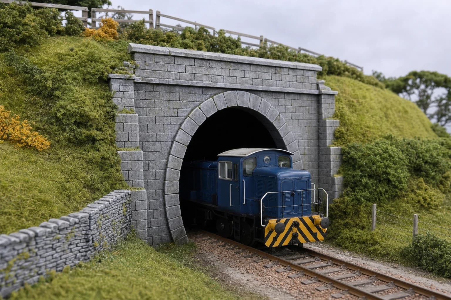 Painted O-gauge tunnel portal installed in a model railway layout